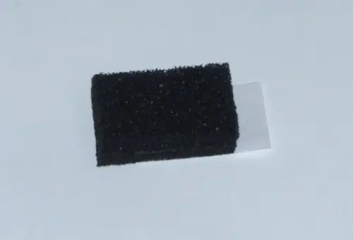 Schwarzes Dichtungsmaterial in rechteckiger Form, möglicherweise für eine Abdeckung, auf hellem Hintergrund. Geeignet für eine Anwendung von Daikin.